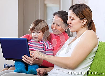 Happy women of three generations with netbook