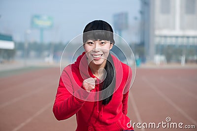 Happy, young and athletic female fitness model in sports outside.