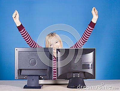 Happy young blonde woman at the two computer s screens