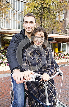 Happy young couple with bicycle near flower market