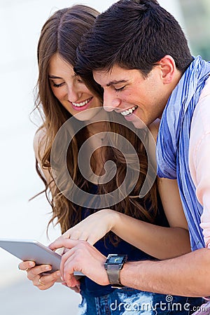 Happy young couple browsing internet with digital tablet in the