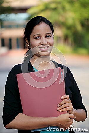 Happy young female student at college campus