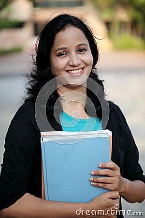 Happy young female student at college campus