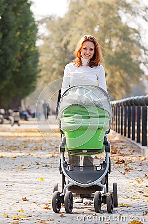 Happy young mother with baby in buggy