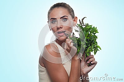 Happy young woman with a bundle of fresh mint. Concept vegetaria
