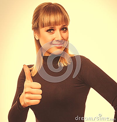 Happy young woman girl shows positive studio sign thumbs yes, in