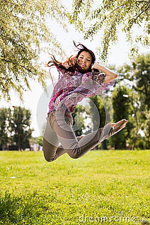 Happy young woman jumping in park