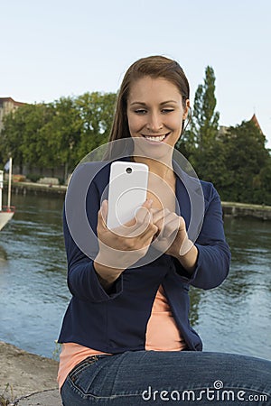 Happy young woman taking pictures with smart phone