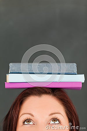 Happy young woman wearing books on her head