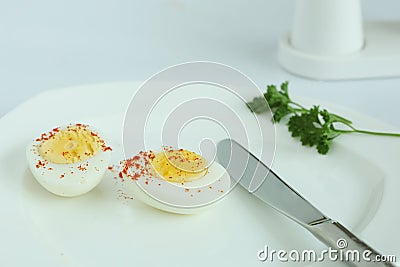 Hard boiled eggs sliced halves in white plate