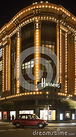 Harrods department store. Taxi passes in front of it