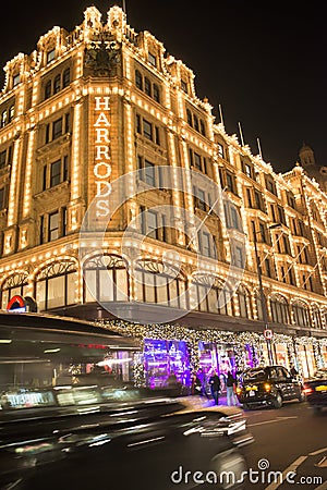 Harrods department store. Taxi passes in front of it