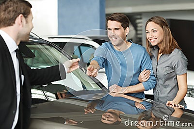 They have made a right vehical choise. Young car salesman giving