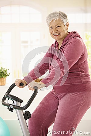 Healthy elderly woman on exercise bike