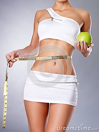 Healthy female body with apple and measuring tape.