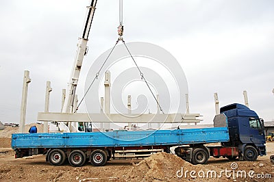 Heavy machinery lifting a concrete pillar