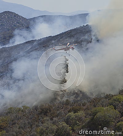 Helicopter drops retardent on fire