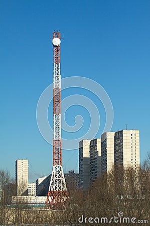 High communication tower with round antenna in a city