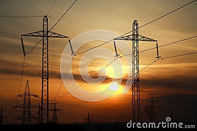 High power electric line towers at dramatic sunset