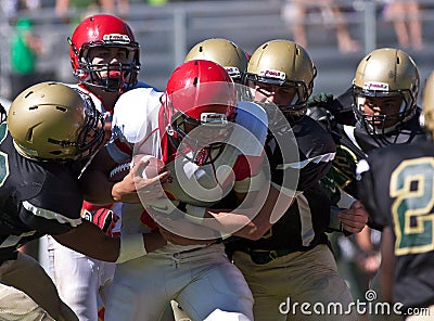 High School Football Player Being Tackled During a Game