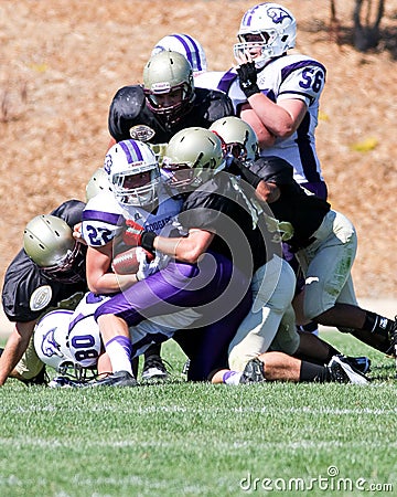 High School Football Player Being Tackled During a Game