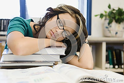 High School Student Sleeping on a Stack of Books