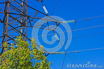 High voltage power pylon against blue sky