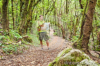 Hiker trekking with map in forest