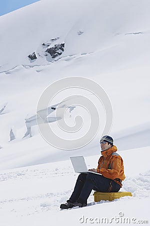 Hiker Using Laptop On Snowy Mountain Landscape