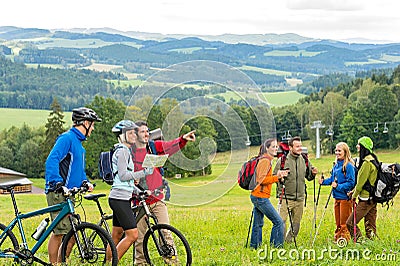 Hikers helping cyclists following track nature landscape