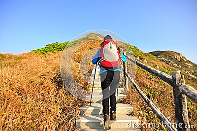 Hiking woman climbing stairs on mountain