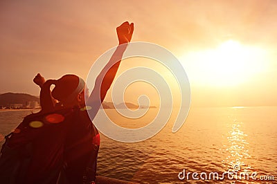 Hiking woman raised arms to sunrise