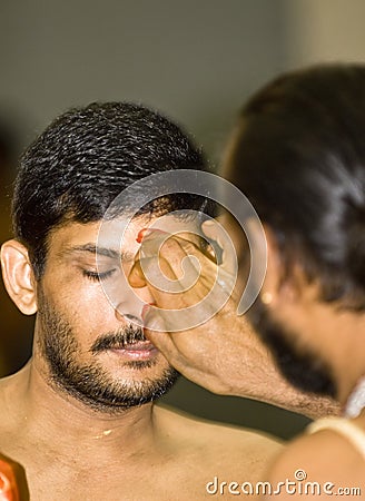 Hindu priest places a mark on the forehead