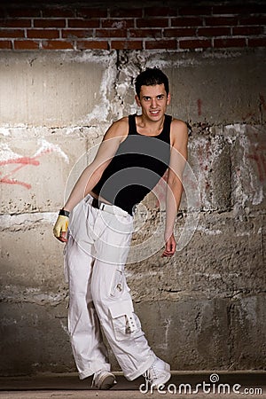 Hip hop boy dancing in modern style over grey wall