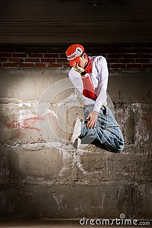 Hip hop boy dancing over grey brick wall