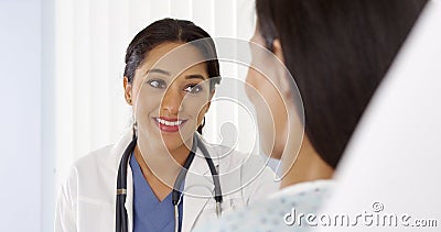 Hispanic doctor talking to female patient