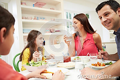 Hispanic Family At Table Eating Meal Together
