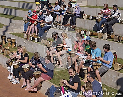 Holidaymakers learning to beat African drums