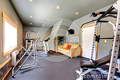 Home gym with yellow couch and TV