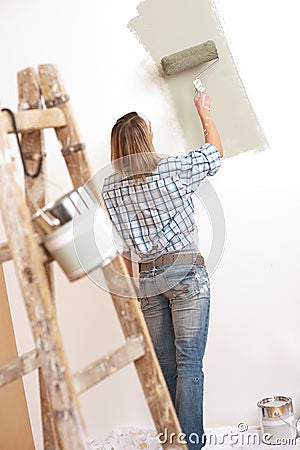 Home improvement: Blond woman painting wall