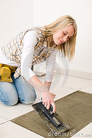 Home improvement, renovation - woman laying tile