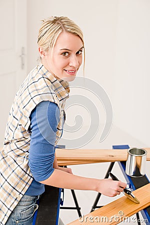 Home improvement - woman painting wooden plank