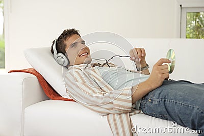 Home Tech on Sofa Listening to Headphones