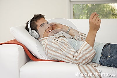 Home Tech on Sofa Listening to Headphones