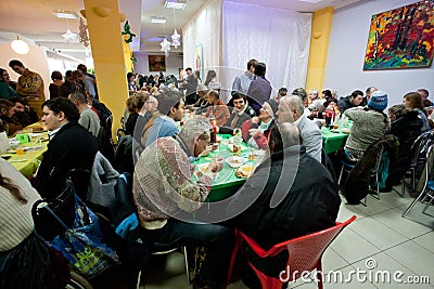 Homeless and unhealthy people eat food at the Christmas charity dinner for the homeless