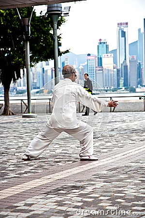 Elderly man is practising Tai Chi in Hong Kong at Victoria Harbour