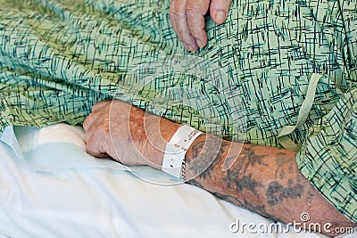 Hospitalized man s arm with ID bracelet