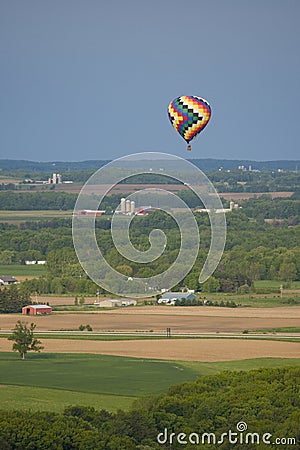Hot air balloon flying over farm lands