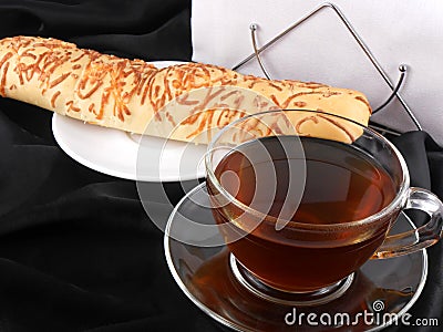 Hot tea with bread on black background