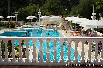 Hotel pool viewed over white stone fence